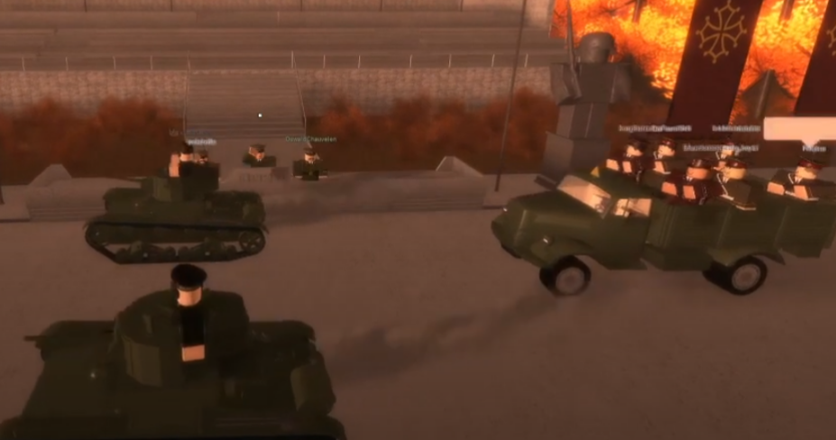 Tanks and trucks drive behind several rows of parading infantry units, their heads faced to the right as they drive by